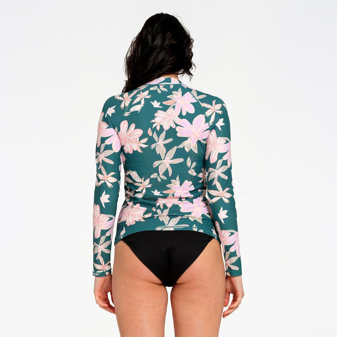 A woman shown from the back wearing a long-sleeve floral swim rash guard in teal green with pink and white flowers, against a plain white background.
