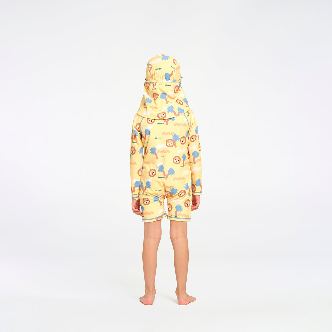 A child standing with their back to the camera, wearing a one-piece swimsuit and hat in a yellow colour with a colorful cartoon pattern of blue, orange, and brown elements.
