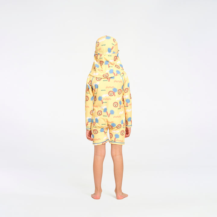 A child standing with their back to the camera, wearing a one-piece swimsuit and hat in a yellow colour with a colorful cartoon pattern of blue, orange, and brown elements.
