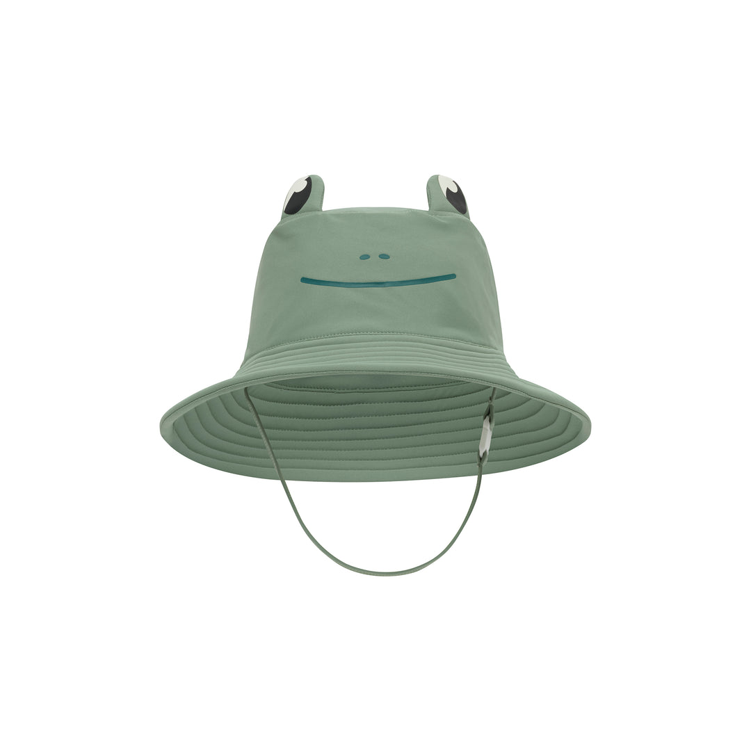 A sage green children's sun hat with a frog face design on the front and two raised frog ears with black and white accents. A thin chin strap hangs below the brim, photographed against a solid white background.