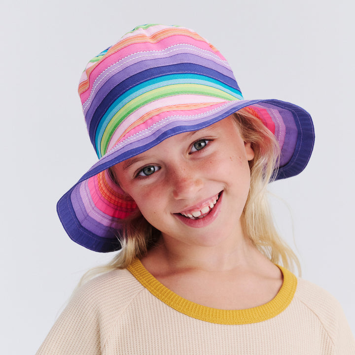 Child wearing a colorful striped hat on a white background