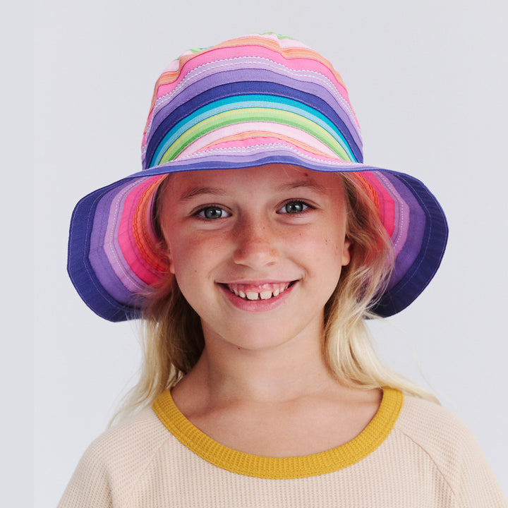 Child wearing a colorful rainbow hat on a white background