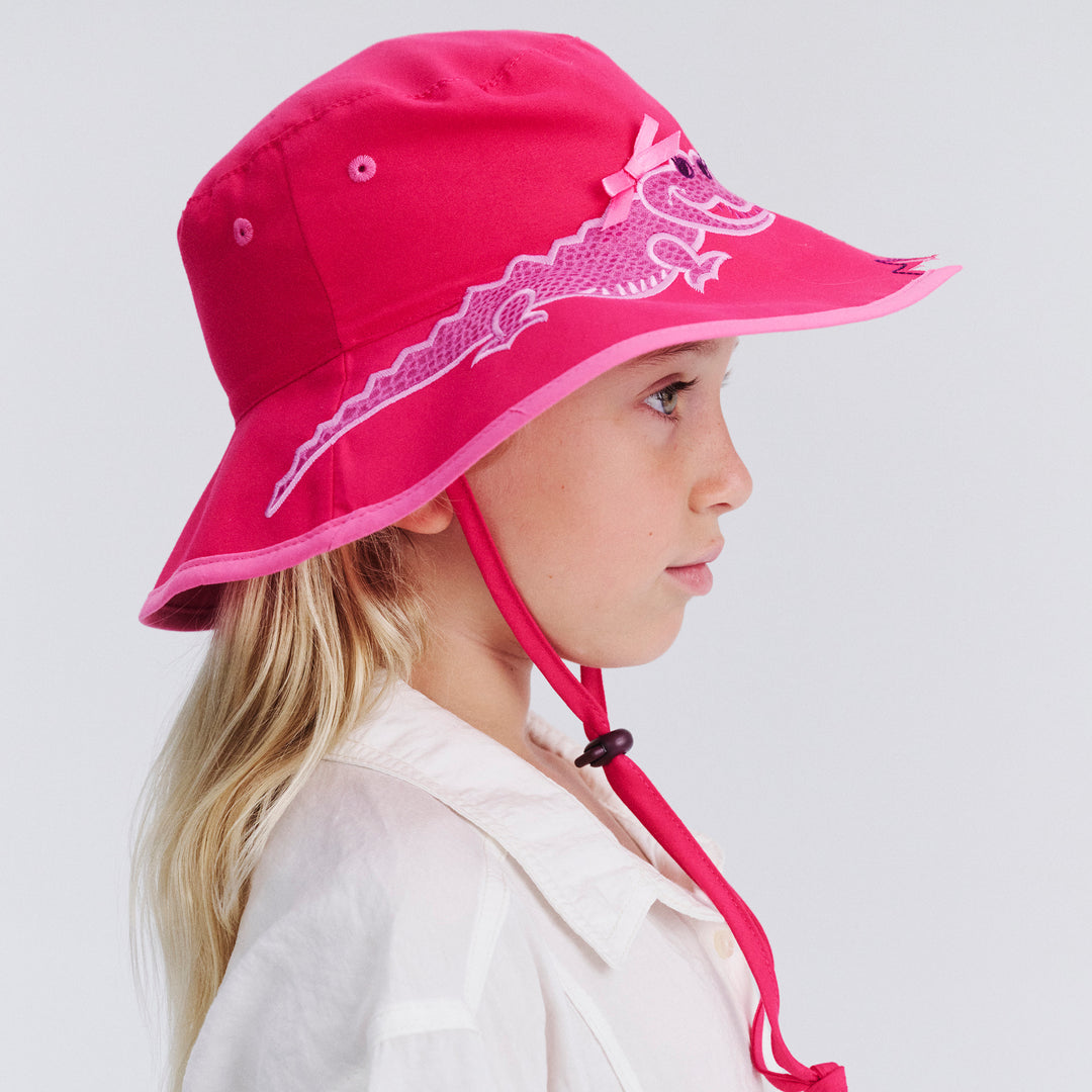 Side profile of child model wearing Awesome wide brim hat in Pink Croc