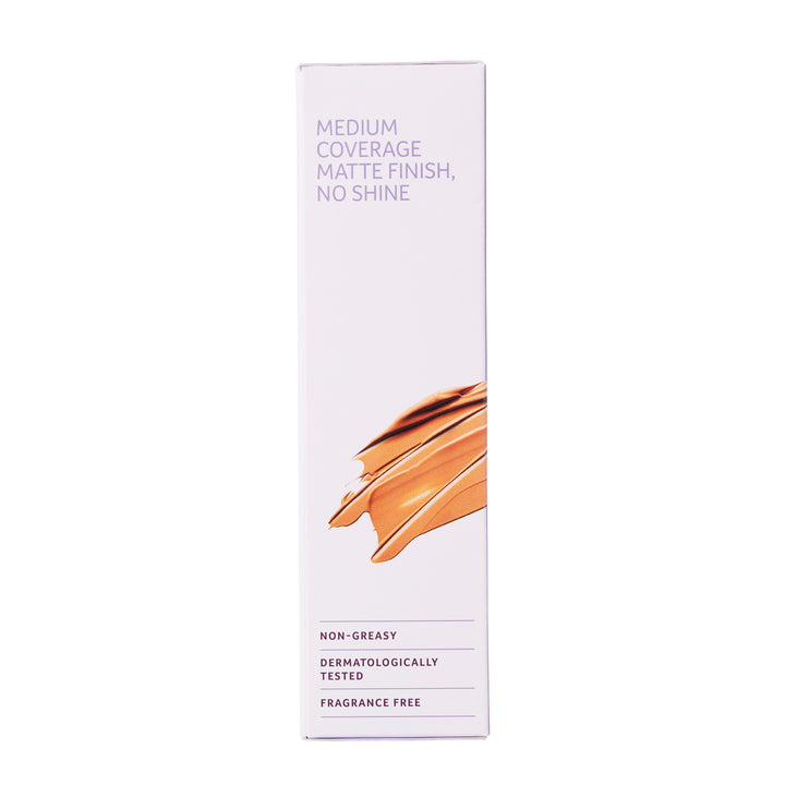 A tall, narrow white cosmetic box with purple text reading 'MEDIUM COVERAGE MATTE FINISH, NO SHINE' and a swatch of warm beige foundation on the front, shown on a plain white background.