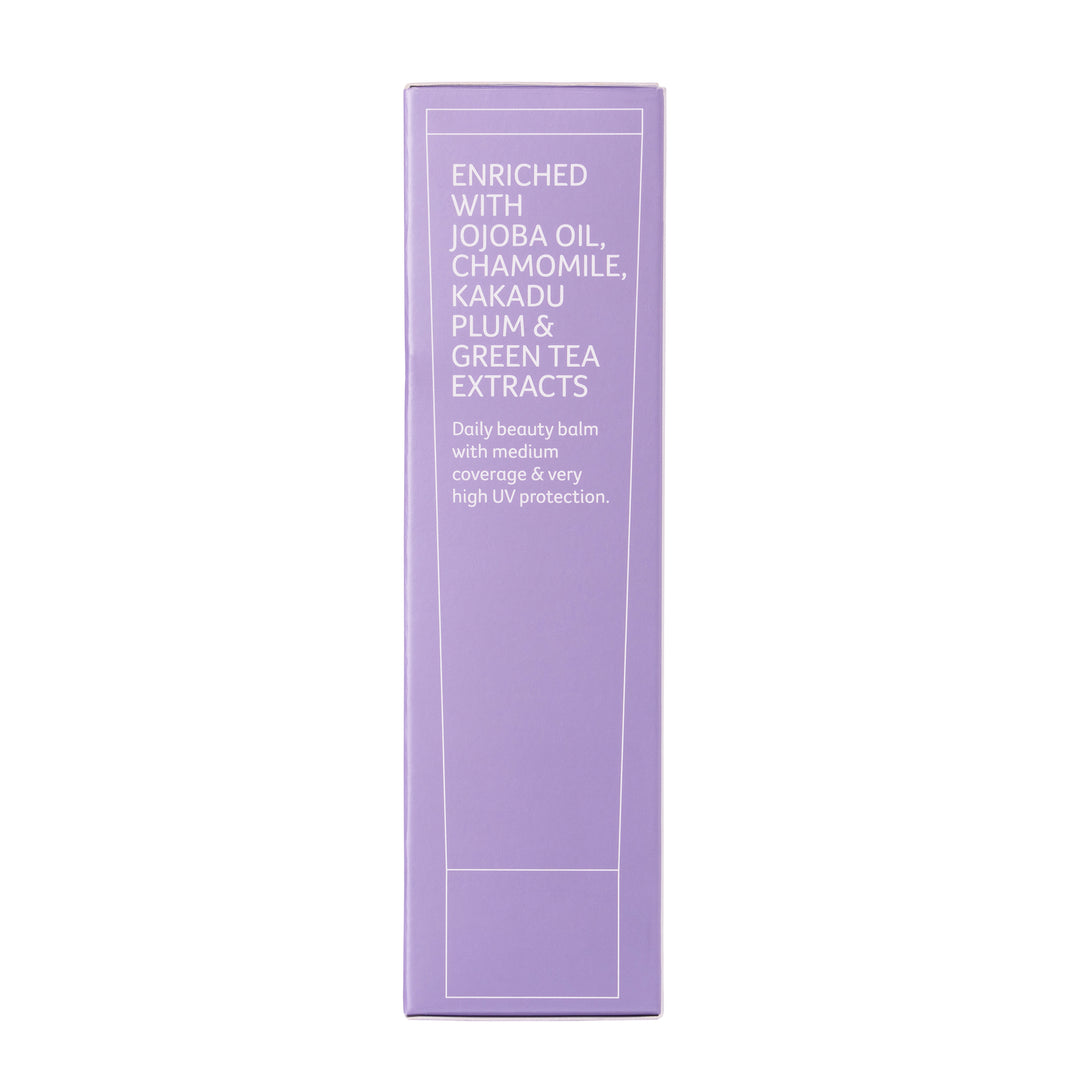 A tall, narrow lavender purple box for a beauty balm, featuring white text that lists ingredients like jojoba oil, chamomile, kakadu plum, and green tea extracts, set against a plain white background.