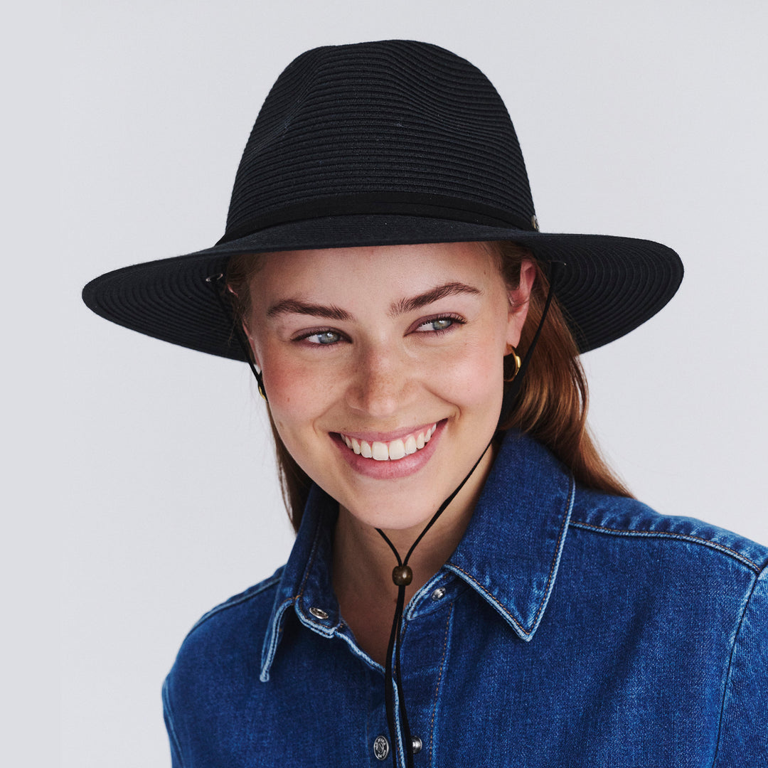 Female model wearing Jody Fedora Hat in Black colour, similing and highlighting shape and silhouette
