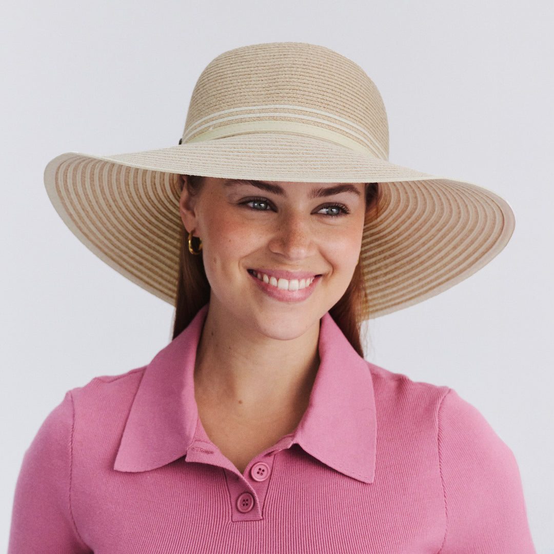 Female model wearing Amy Striped Capeline Hat in camel and ivory mix, front view showcasing fit and sun-protective wide brim