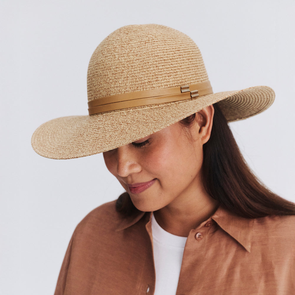 Female model wearing Gena Capeline Hat in camel colour, three-quarter angle highlighting elegant shape and wide brim silhouette