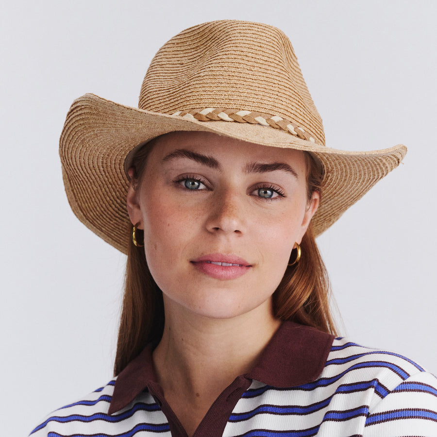 Female model wearing Jesse Raffia Cowboy Hat in natural colour, front view showcasing fit and sun-protective wide brim
