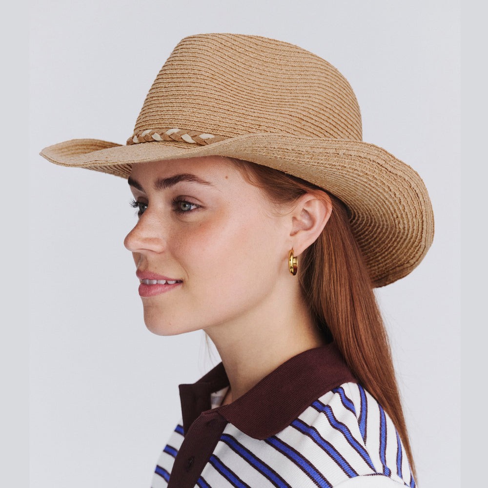 Female model wearing Jesse Raffia Cowboy Hat in natural colour, side profile showing wide brim coverage and structured silhouette