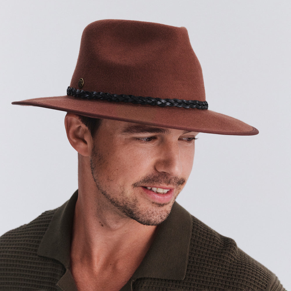 Male model wearing Bartle Fedora Hat in chocolate colour, three-quarter angle highlighting shape and fit