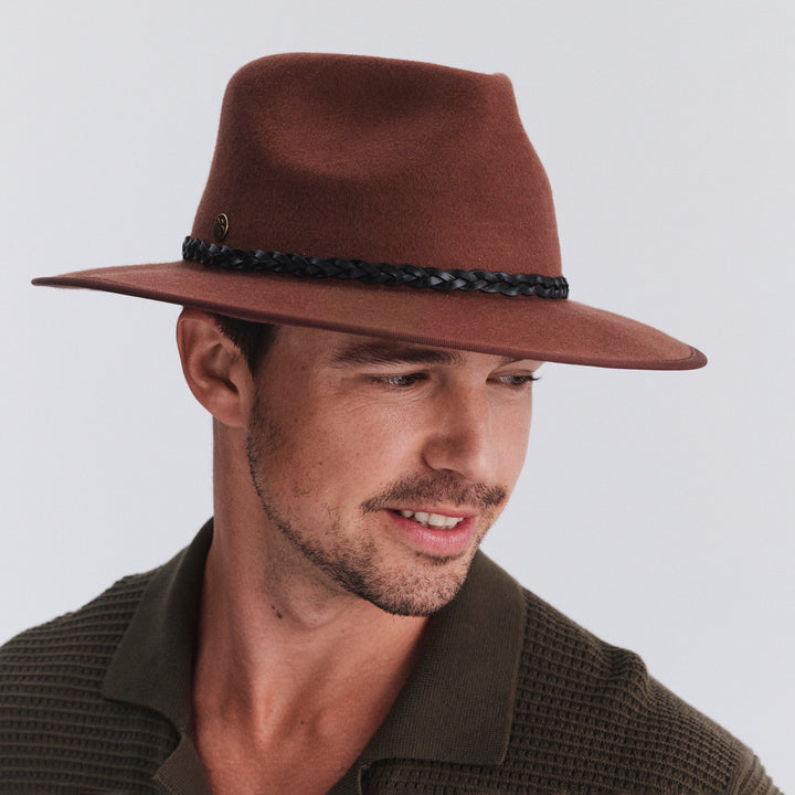 Male model wearing Bartle Fedora Hat in chocolate colour, three-quarter angle highlighting shape and fit