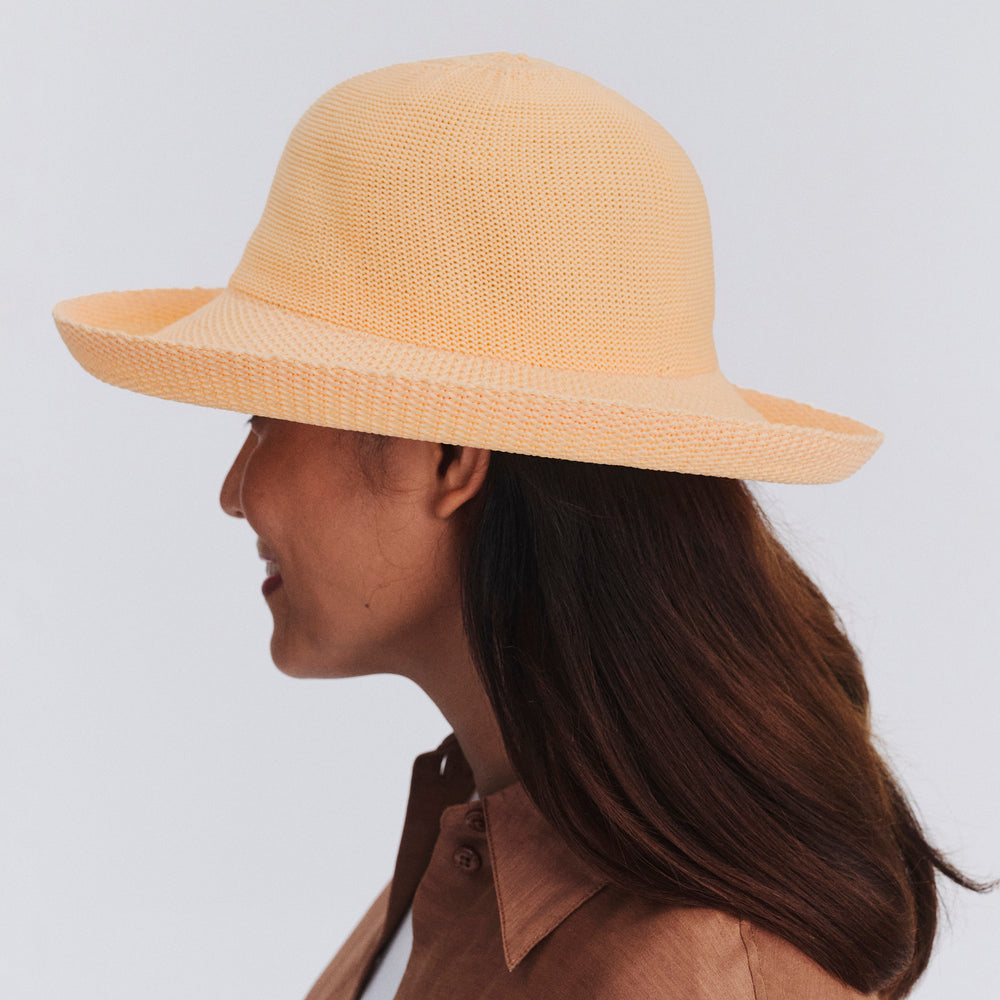 Female model wearing Classic Breton Hat in Apricot colour, side profile showing brim coverage