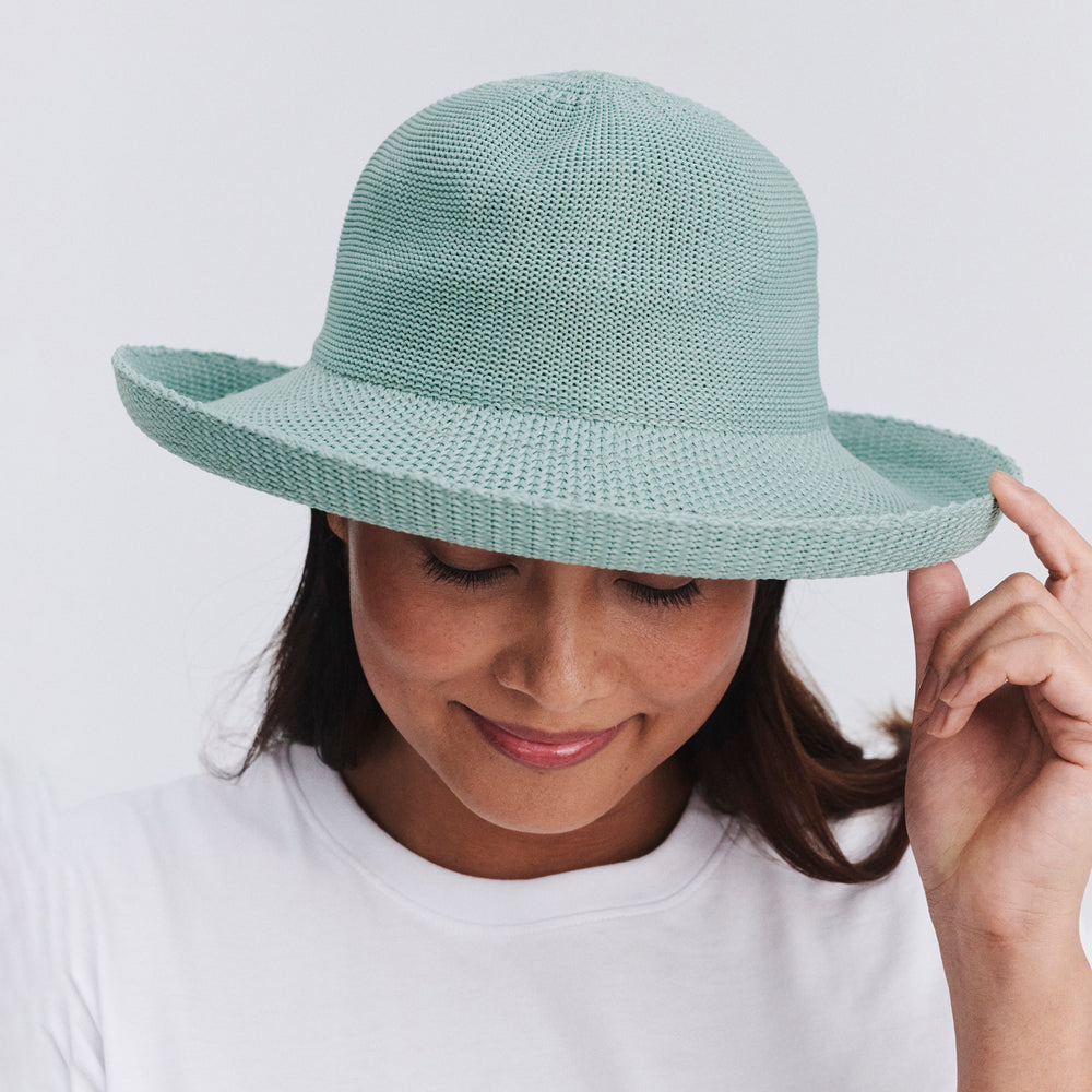 Female model wearing Classic Breton Hat in blue haze colour, front view with brim tipped down to show crown