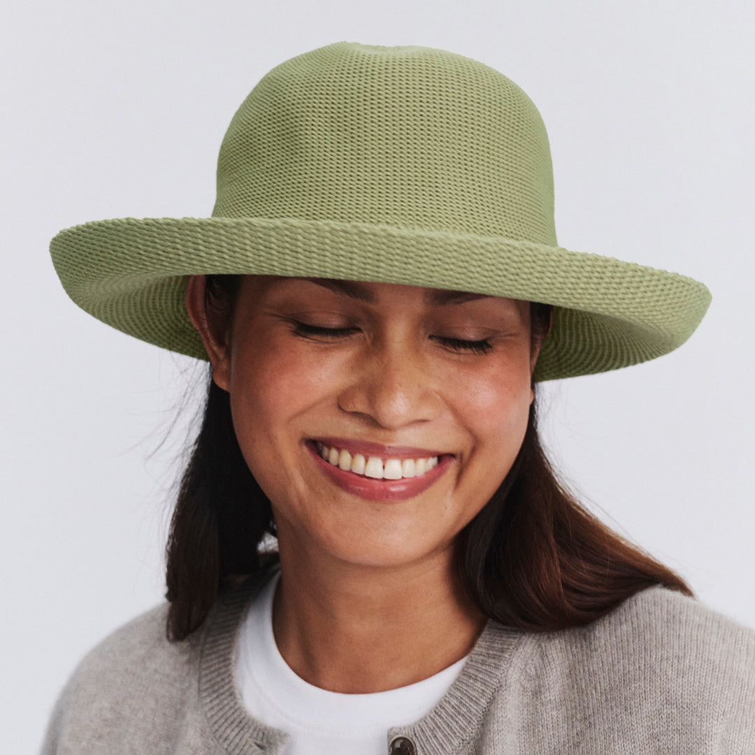 Female model wearing Classic Breton Hat in light moss green colour, eyes closed