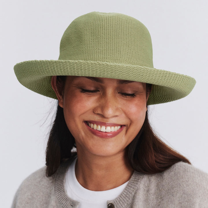 Female model wearing Classic Breton Hat in light moss green colour, eyes closed