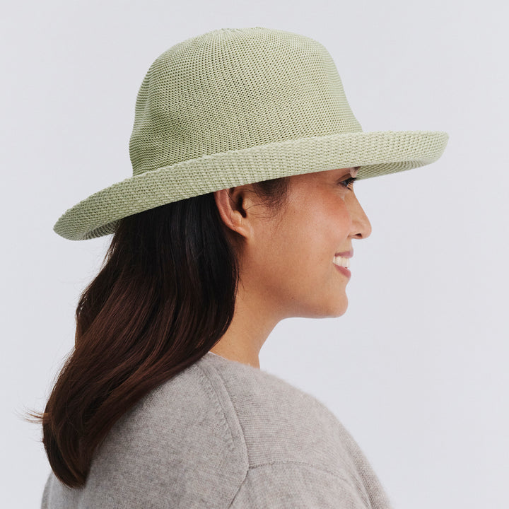 Female model wearing Classic Breton Hat in light moss green colour, side profile showing crown shape and brim detail