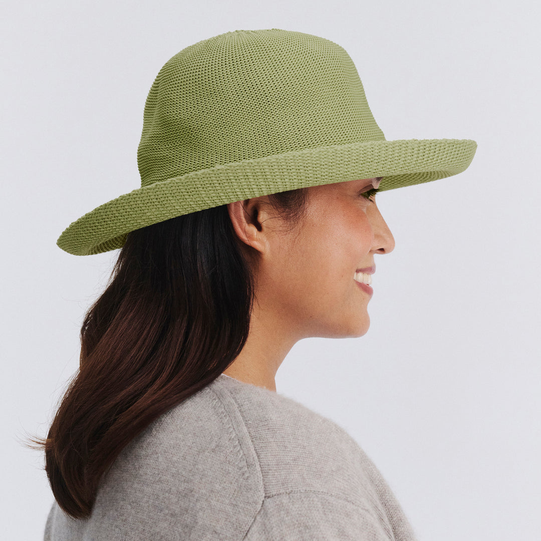 Female model wearing Classic Breton Hat in light moss green colour, side profile showing crown shape and brim detail