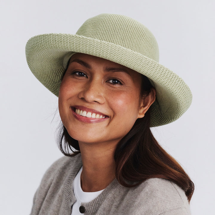 Female model wearing Classic Breton Hat in light moss green colour, front view styled with neutral clothing