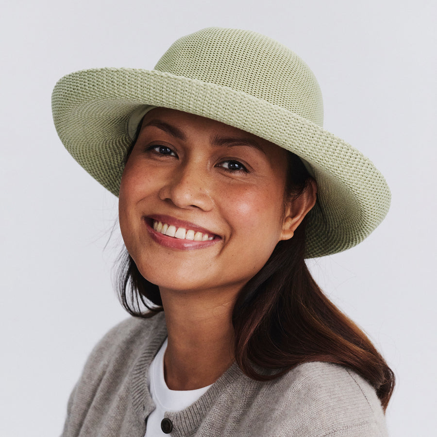 Female model wearing Classic Breton Hat in light moss green colour, front view styled with neutral clothing