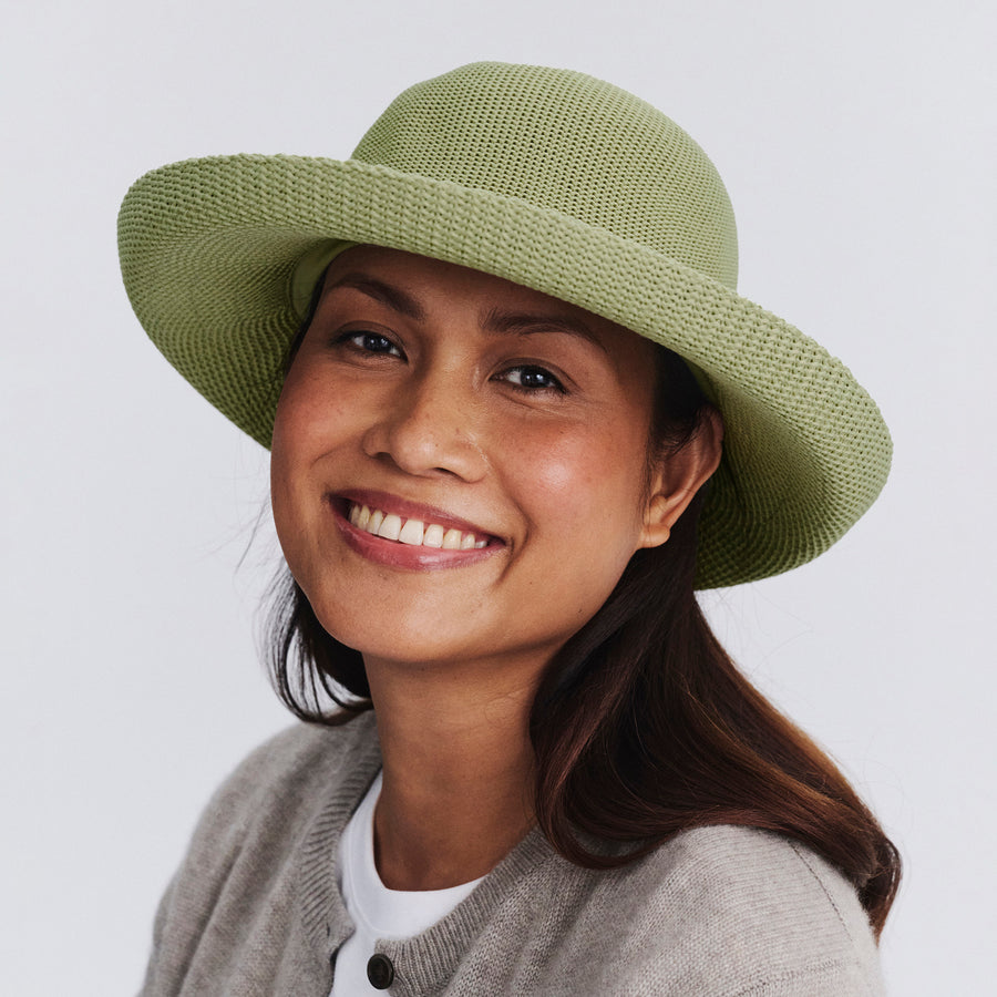 Female model wearing Classic Breton Hat in light moss green colour, front view styled with neutral clothing