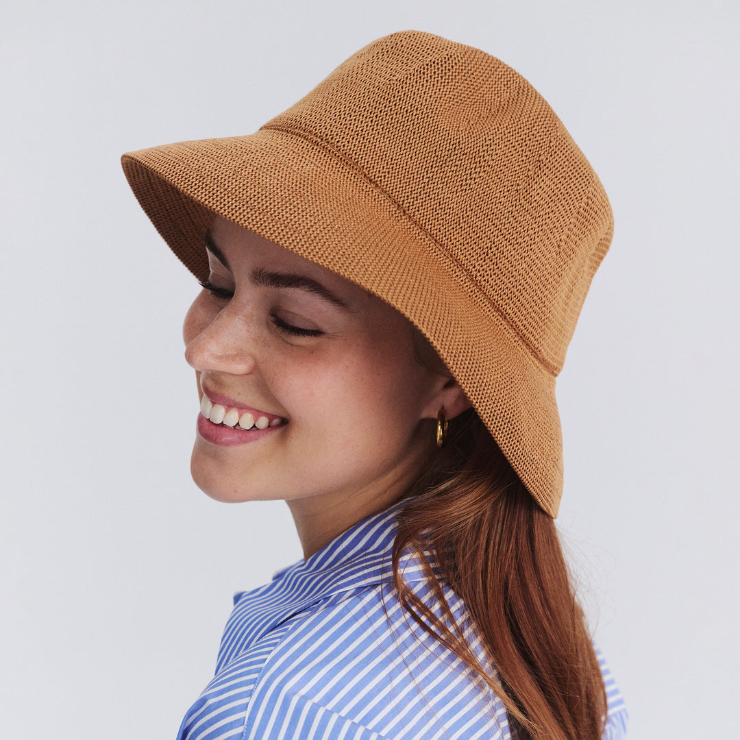 Female model wearing Tamzin Bucket Hat in biscuit colour, three-quarter angle highlighting fit and silhouette