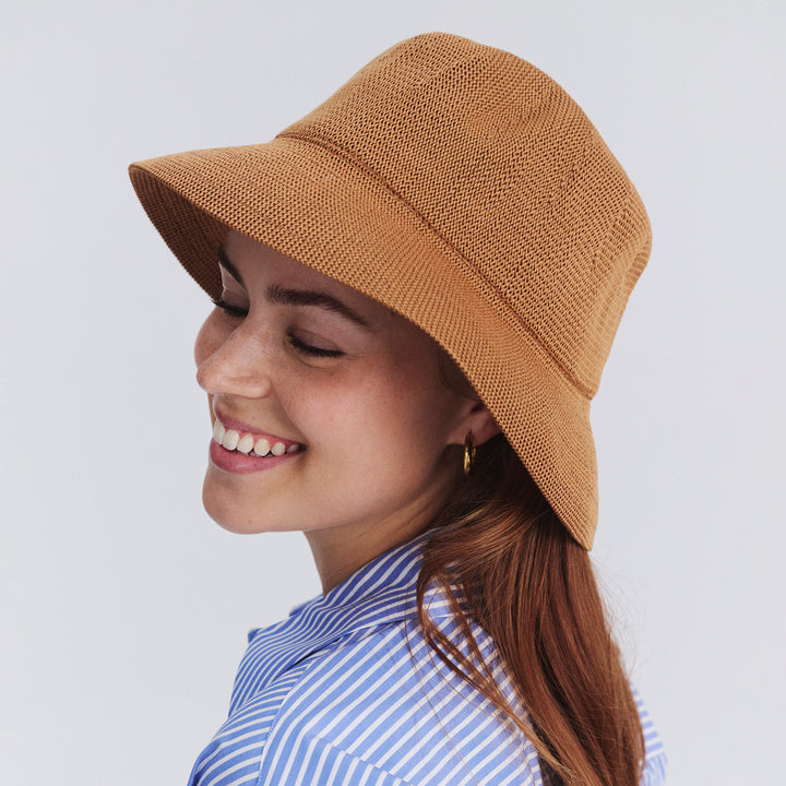 Female model wearing Tamzin Bucket Hat in biscuit colour, three-quarter angle highlighting fit and silhouette