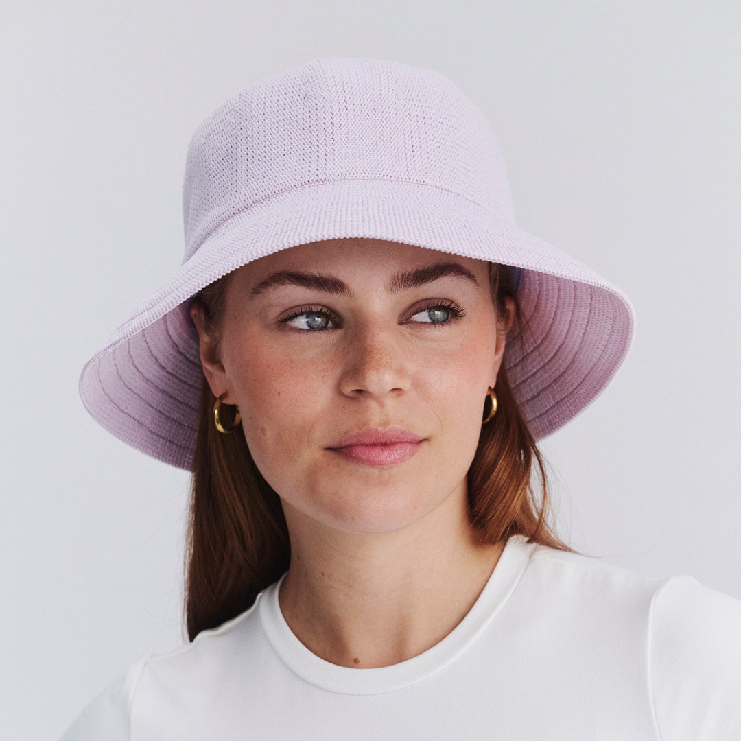 Female model wearing Tamzin Bucket Hat in Lilac colour, front view showcasing fit and wide brim