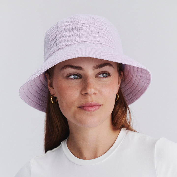 Female model wearing Tamzin Bucket Hat in Lilac colour, front view showcasing fit and wide brim