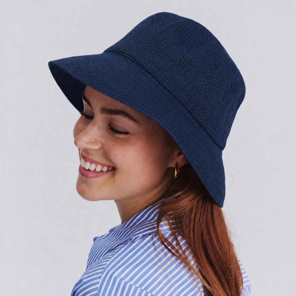 Female model wearing Tamzin Bucket Hat in navy colour, side profile showing relaxed silhouette and brim coverage