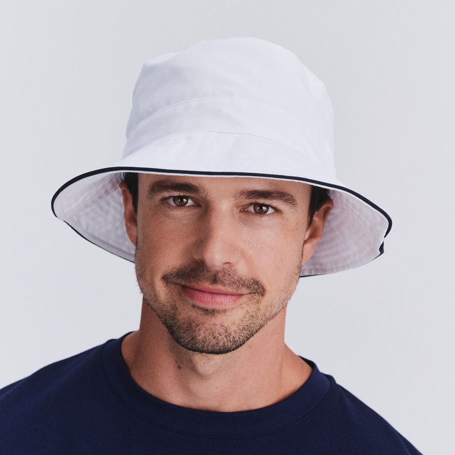Male model wearing Jester bucket hat in White/Navy, front‑facing view