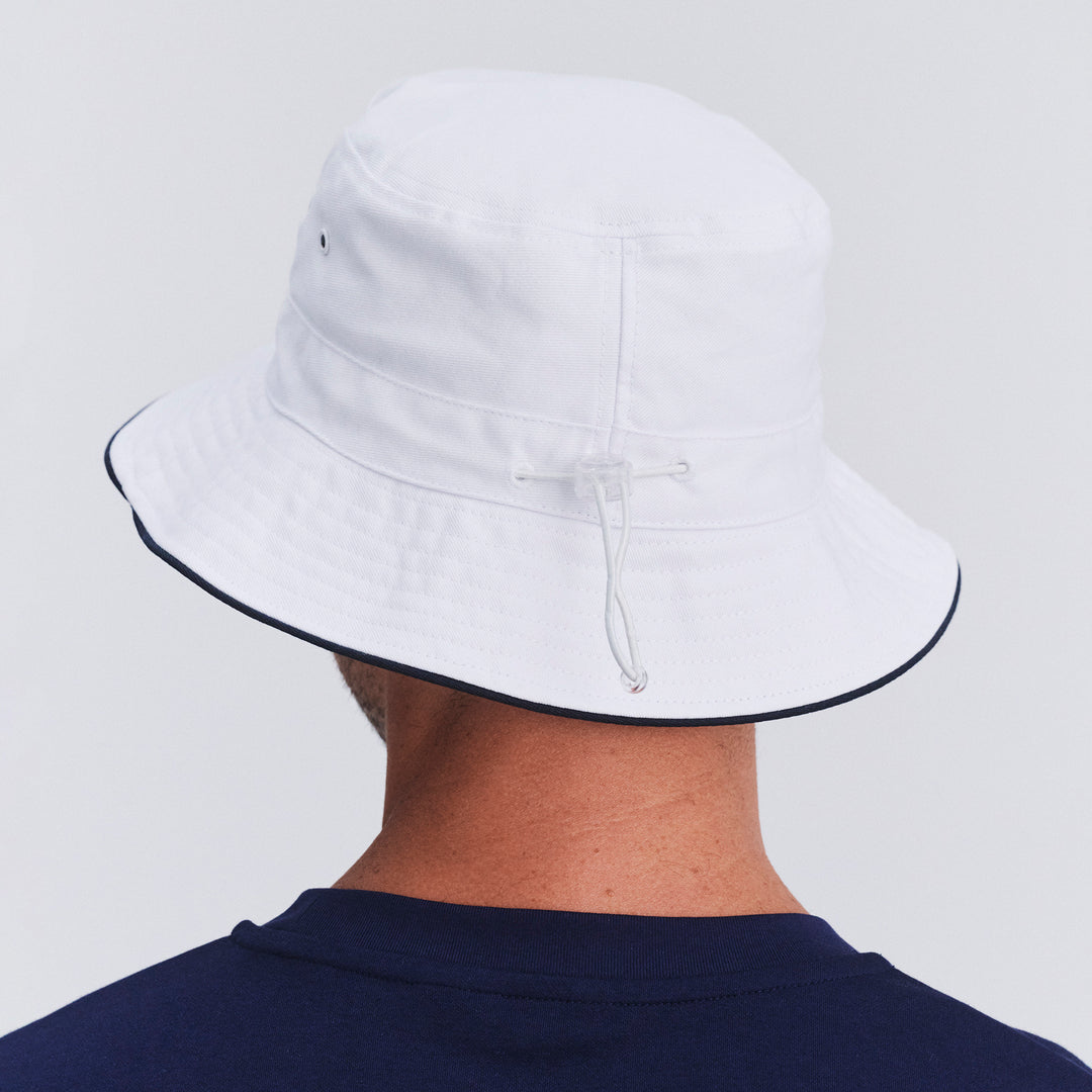 Back view of male model wearing Jester bucket hat in White/Navy showing brim shape and rear detailing