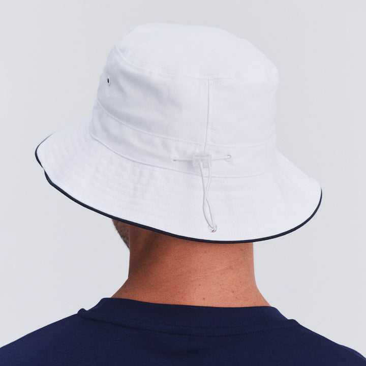 Back view of male model wearing Jester bucket hat in White/Navy showing brim shape and rear detailing