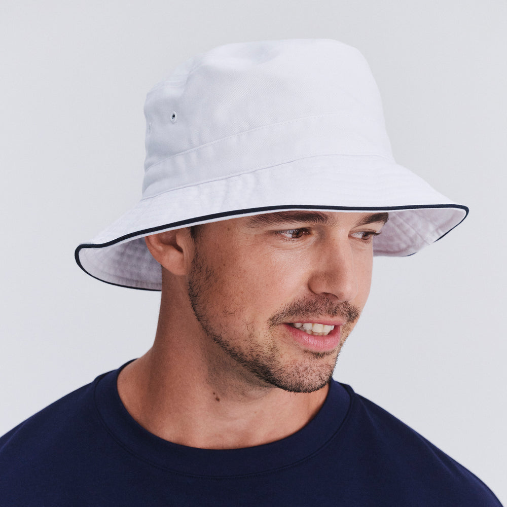 Male model wearing Jester bucket hat in White/Navy, three‑quarter angle