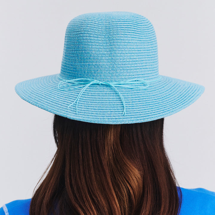 Back view of female model wearing Lacey bucket hat in Mixed Blue showing brim shape and rear detailing