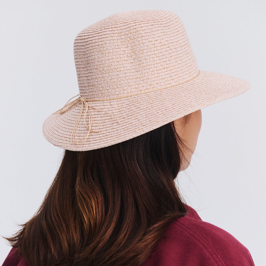 Back view of female model wearing Lacey bucket hat in Soft Pink showing brim shape and rear detailing
