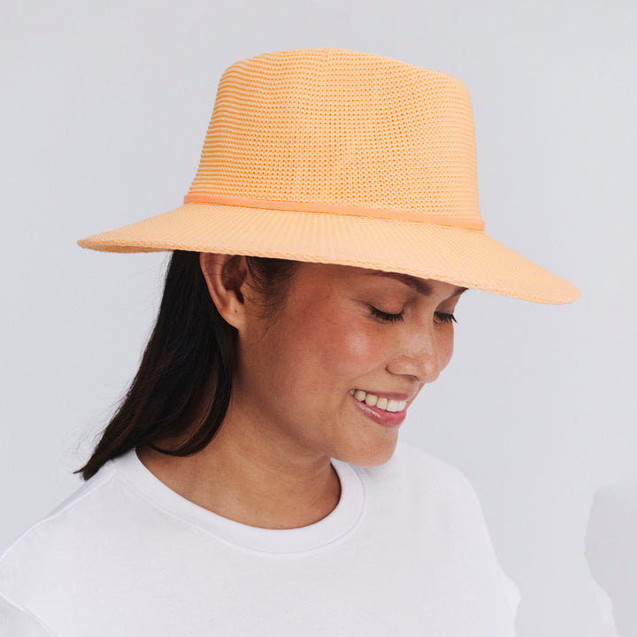 Female model wearing Jacqui Mannish Hat in Apricot colour, side profile showing brim coverage