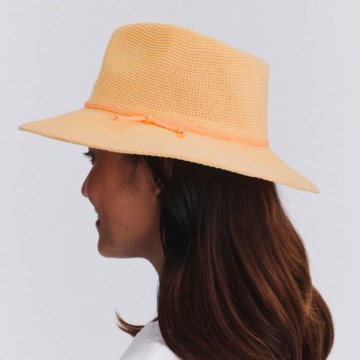 Female model wearing Jacqui Mannish Hat in Apricot colour, back view showing crown shape