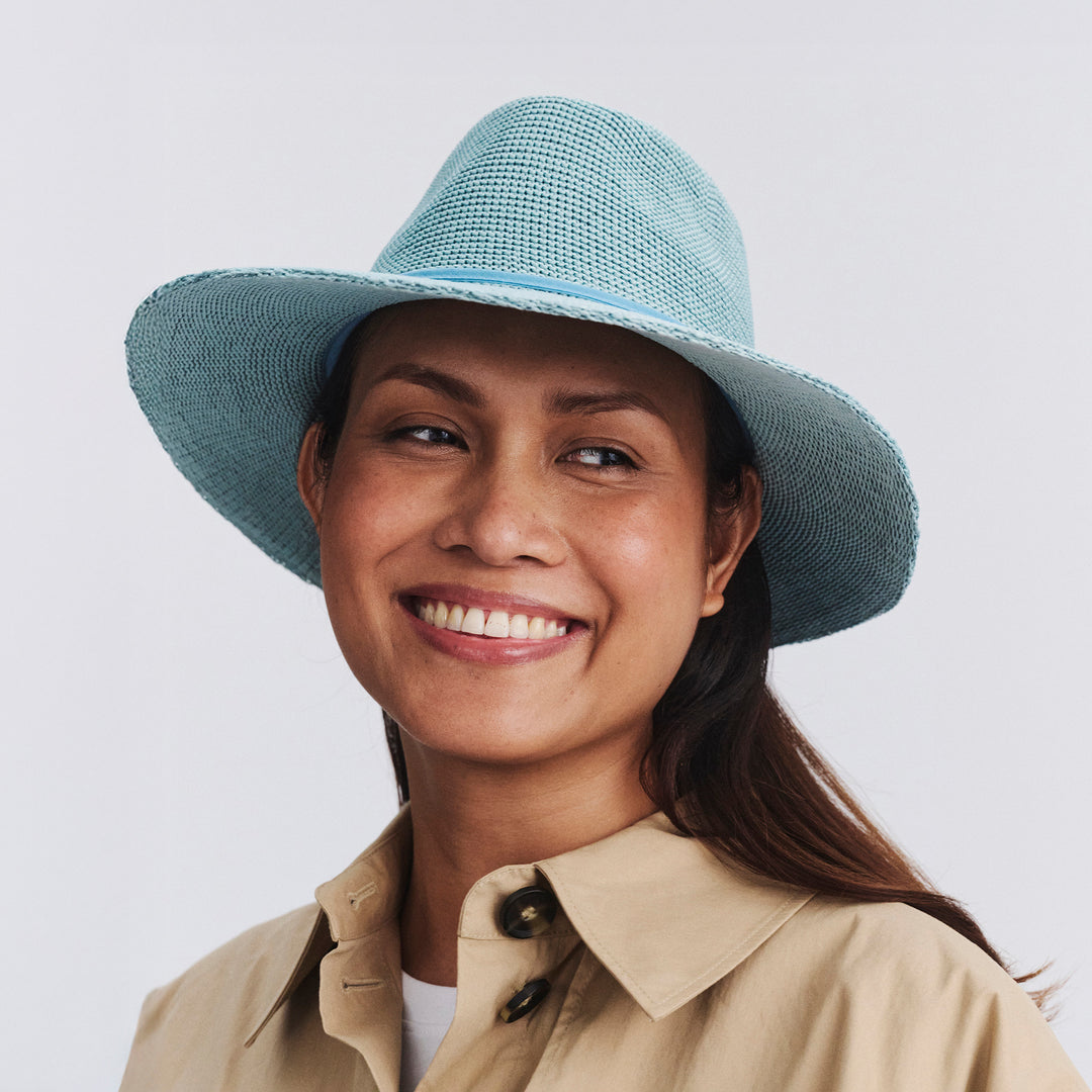 Female model wearing Jacqui Mannish Hat in blue haze colour, front view styled with neutral outfit