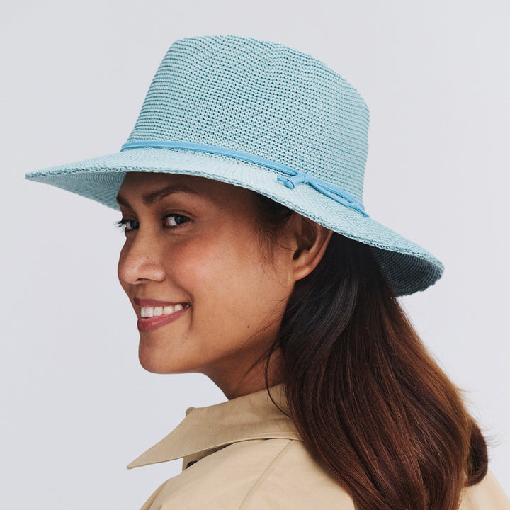 Female model wearing Jacqui Mannish Hat in blue haze colour, side profile showing structured shape and brim detail