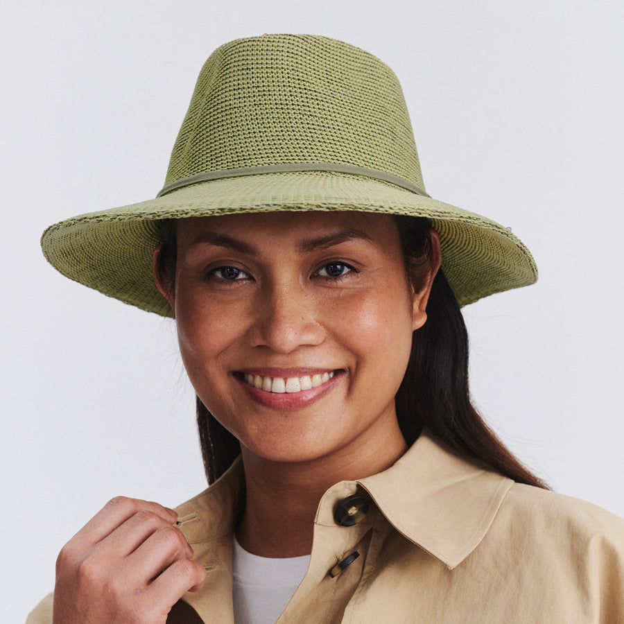 Female model wearing Jacqui Mannish Hat in light moss green colour, front view styled with beige shirt