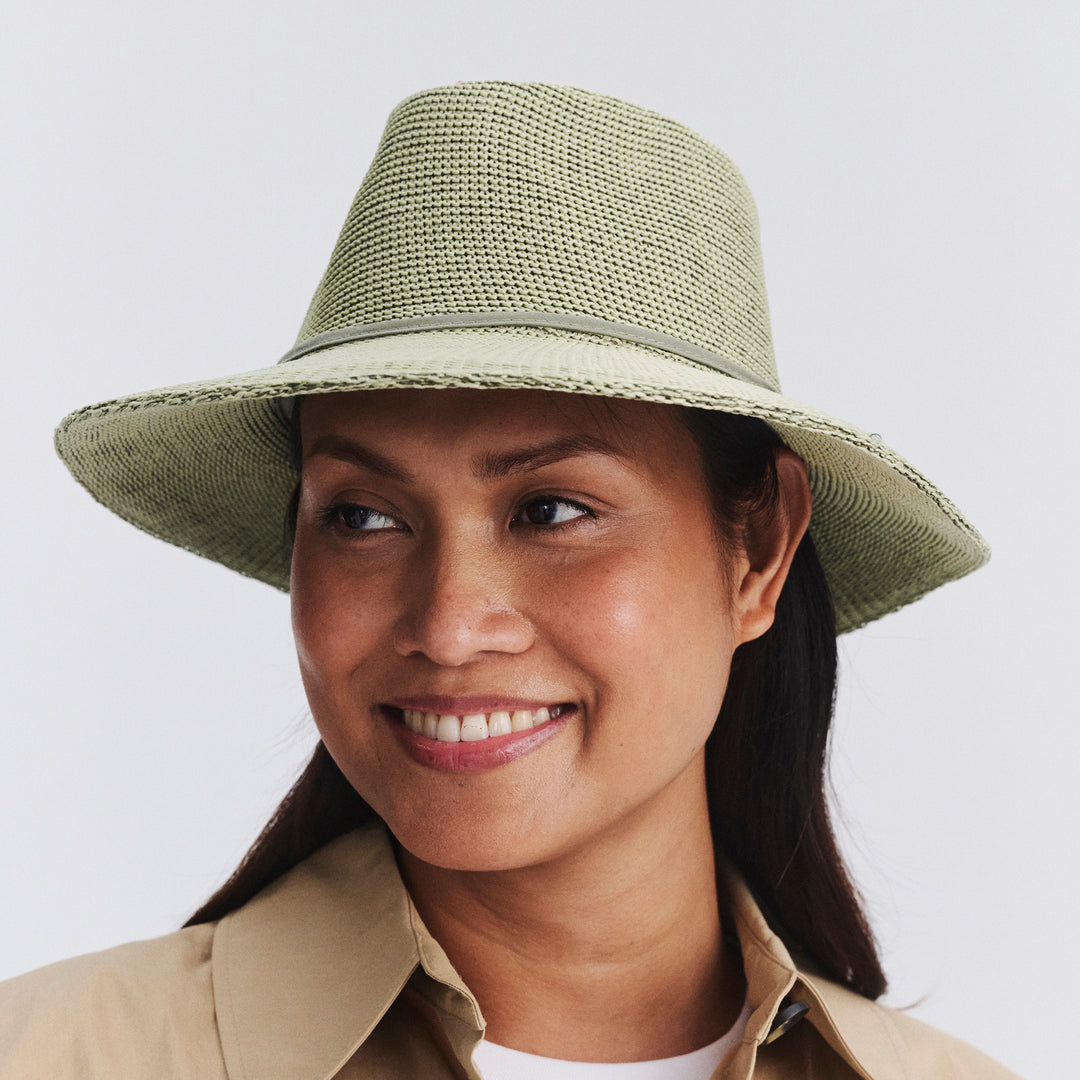 Female model wearing Jacqui Mannish Hat in light moss green colour, three-quarter angle highlighting fit and silhouette