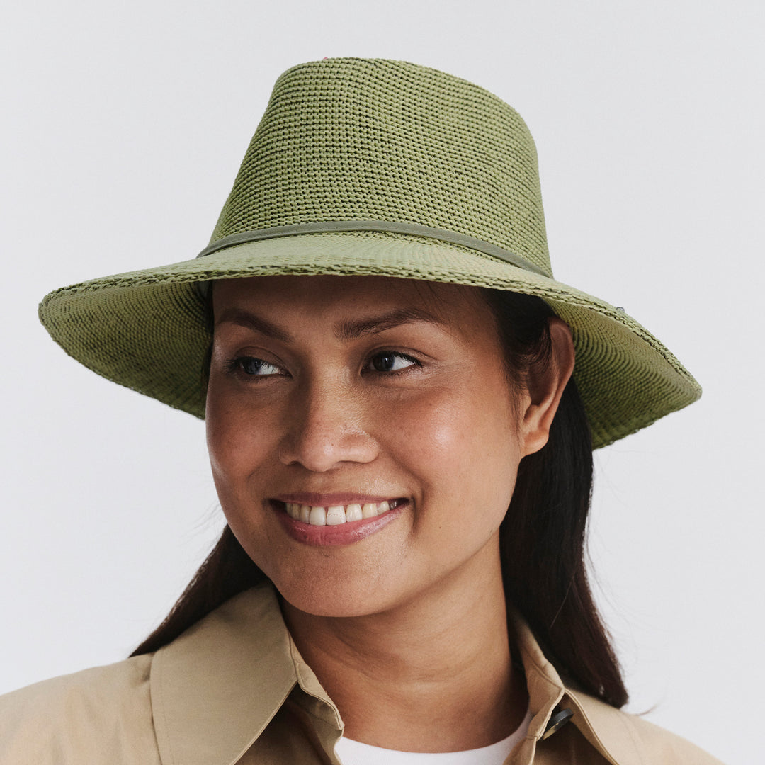 Female model wearing Jacqui Mannish Hat in light moss green colour, three-quarter angle highlighting fit and silhouette