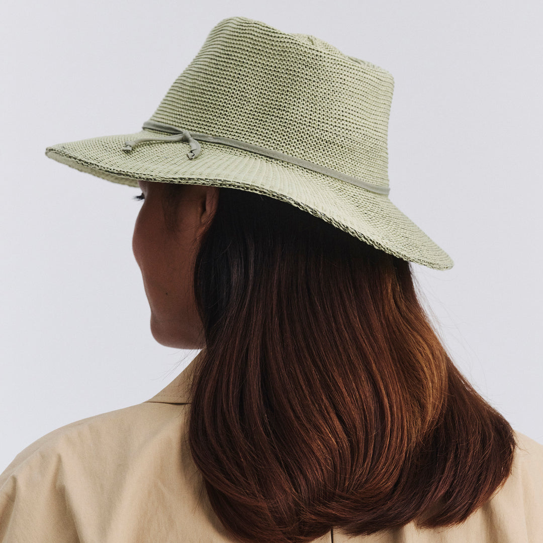 Female model wearing Jacqui Mannish Hat in light moss green colour, back view showing fit and rear crown shape