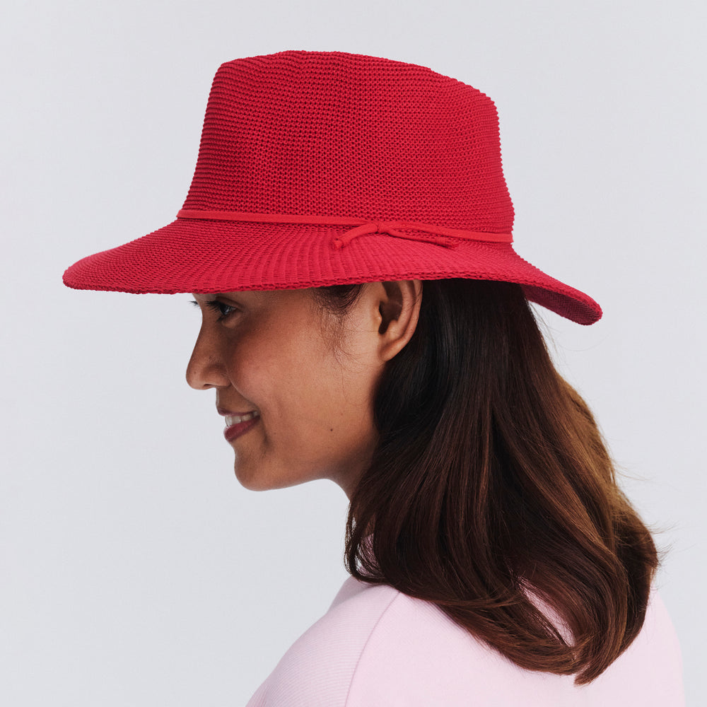 Female model wearing Jacqui Mannish Hat in red poppy colour, side profile showing structured shape and brim detail