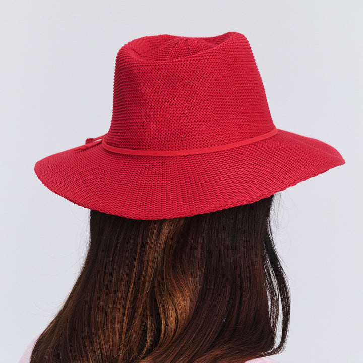 Female model wearing Jacqui Mannish Hat in red poppy colour, back view showing fit and rear crown shape