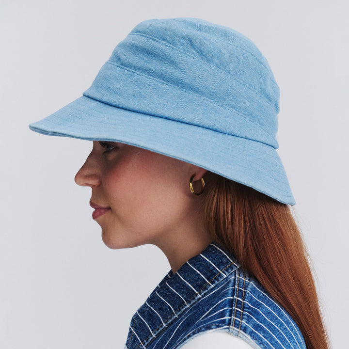 Side profile of female model wearing Golf bucket hat in Denim