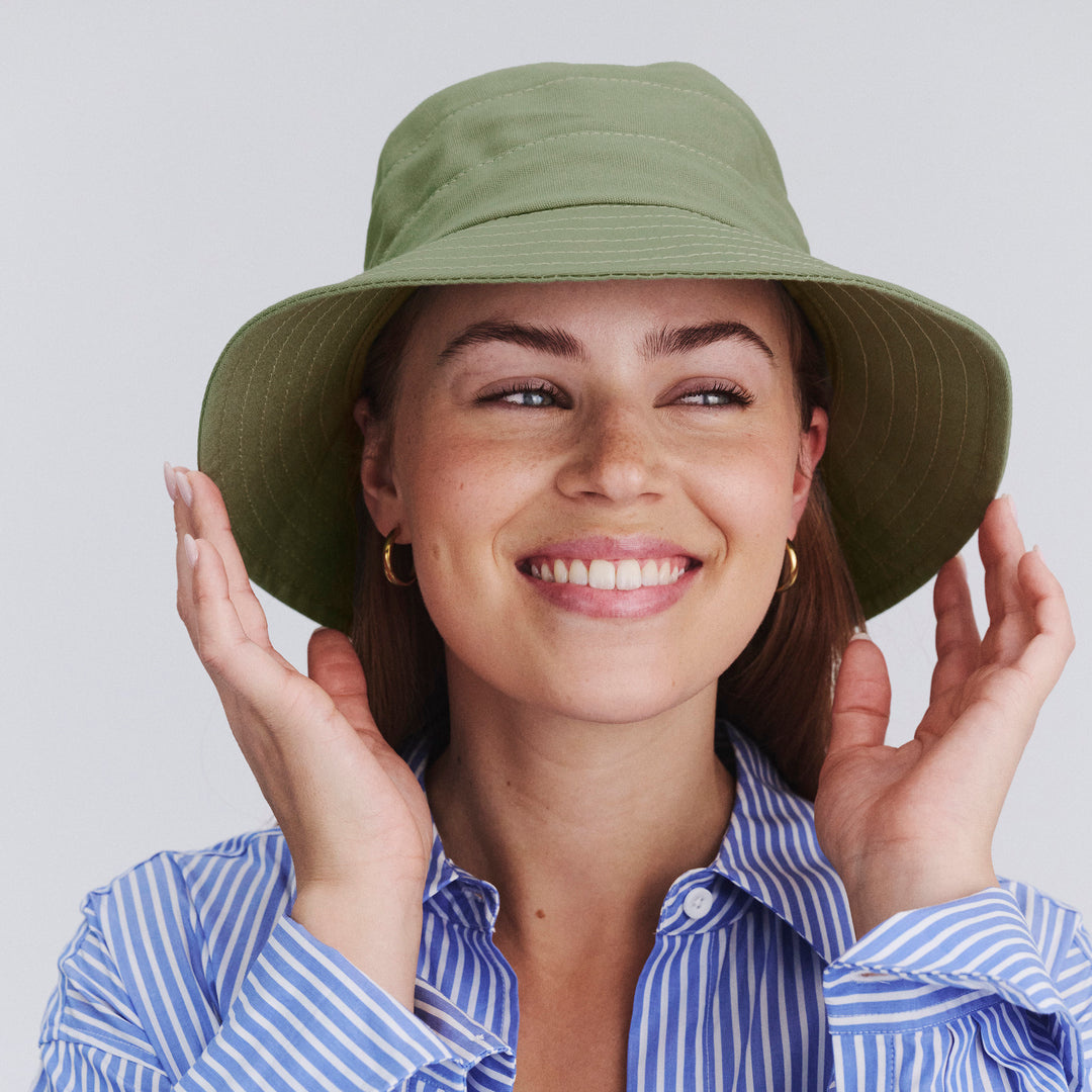 Female model wearing Golf Bucket Hat in sage colour, front view showcasing relaxed fit and sun coverage
