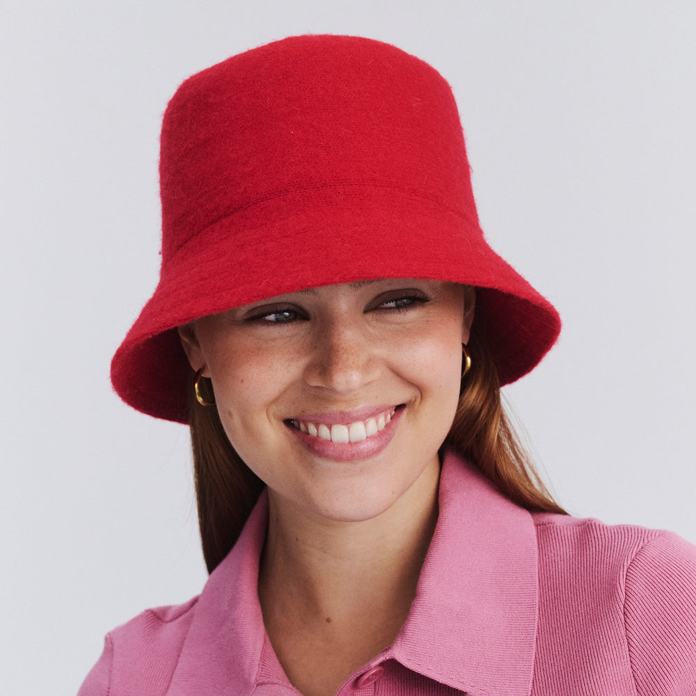 Female model wearing Isadora Bucket Hat in red colour, front view styled with casual outfit
