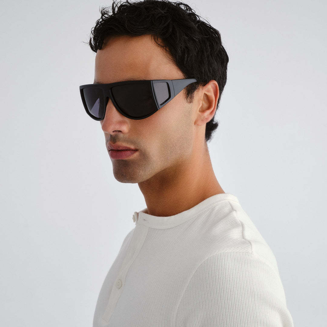 Male model wearing Nash sunglasses in matte black, angled view showcasing fit and frame style